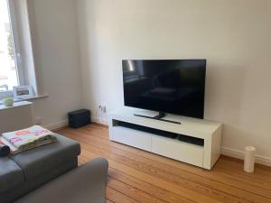 a living room with a flat screen tv on a white entertainment center at Wohlfühlen in Winterhude in Hamburg