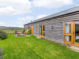 a small grey house with a grass yard at 3 Bed in Sherborne 65854 in Pointington