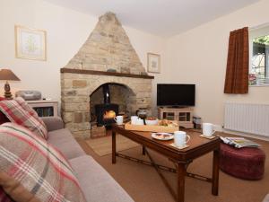 a living room with a stone fireplace and a table at 2 Bed in Rowlands Gill CN192 in Stanley