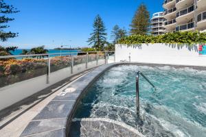 un jacuzzi en una piscina al lado de un edificio en Sirocco 404 luxurious 3 bedroom unit, ocean front, en Mooloolaba