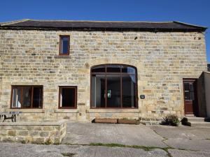 a brick building with a door and a bench in front at 2 bed property in Nidderdale HH011 