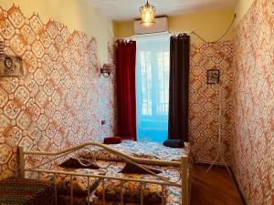 a small bedroom with a bed and a window at Lets Go House in Tbilisi City