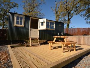 a tiny house on a deck with a picnic table at 1 bed in Llandyfan 65190 in Llandybie
