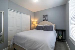 Un dormitorio con una gran cama blanca y una ventana. en Cozy Great Falls Retreat., en Great Falls