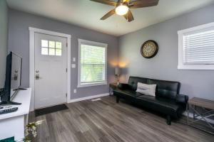Una sala de estar con un sofá y un reloj en la pared. en Cozy Great Falls Retreat., en Great Falls