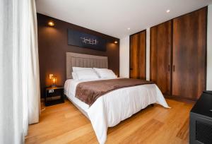 1 dormitorio con 1 cama grande y suelo de madera en Morph Candelaria en Bogotá