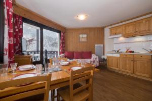レ・ズッシュにあるAppartement Anaïte 15 - Happy Rentalsのキッチン、ダイニングルーム(木製テーブル、椅子付)