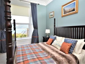 Un dormitorio con una cama con paredes azules y una ventana en 3 Bed in Cove 73939, en Cove