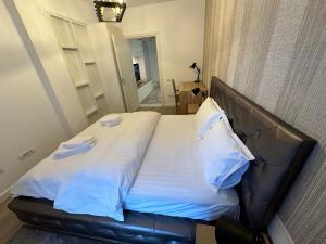 ブラショヴにあるLuxury City Centre Apartments - Brasovのベッドルーム1室(大型ベッド1台、革張りのヘッドボード付)