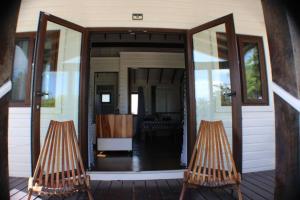 due sedie sedute sul portico di una casa di La Vida Belize - Casita a Riversdale