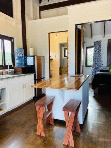 a kitchen with a large island with two wooden stools at La Vida Belize - Casita in Riversdale