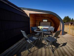 a patio with a table and chairs on a deck at 1 Bed in Teviothead 75347 in Hawick