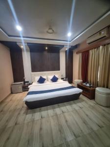 a large bedroom with a large bed with blue pillows at Hotel Himalaya in Bongaigaon