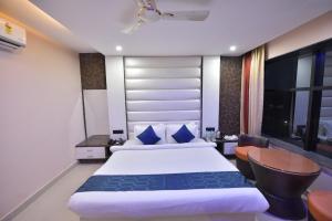 a hotel room with a bed and a desk at Hotel Himalaya in Bongaigaon