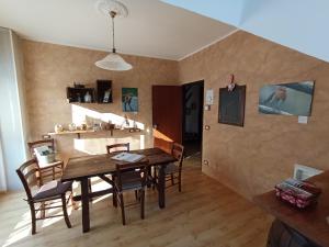 a dining room with a wooden table and chairs at LA ROCCA BIANCA in Demonte +22 photos