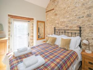 a bedroom with a bed and a stone wall at 2 Bed in North York Moors National Park G0132 in Rosedale Abbey