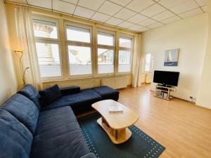 un soggiorno con divano blu e tavolo di Promenadenblick/Captains-Suite a Warnemünde