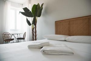 ein Schlafzimmer mit einem weißen Bett mit zwei Handtüchern darauf in der Unterkunft Santa Gloria - (150 m dalla metro) in Sesto San Giovanni