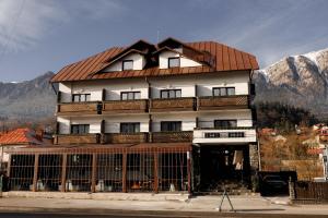 ein großes weißes Gebäude mit rotem Dach in der Unterkunft Suru Hotel & Restaurant in Buşteni