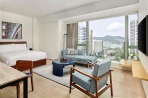 a hotel room with a bed and a couch at Doubletree By Hilton Shenzhen Airport Residences in Shenzhen