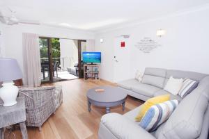 a living room with a couch and a table at Windmill 3 in Mooloolaba