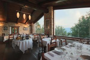 restauracja z białymi stołami i krzesłami oraz dużym oknem w obiekcie Agriturismo Valdifiori w mieście Sassoferrato