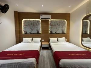 two beds in a room with two windows at OYO 1219 Thien Han Phat Hotel in Da Nang