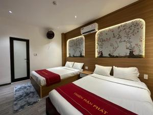 a hotel room with two beds and a mirror at OYO 1219 Thien Han Phat Hotel in Danang