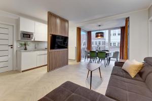 a living room with a couch and a table with chairs at Downtown Apartments Chmielna Park - City Center & Parking in Gdańsk