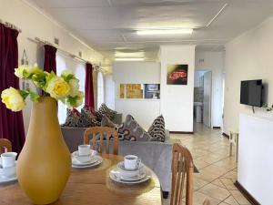 un vaso con fiori gialli su un tavolo in soggiorno di Sombedu guest suite a Margate