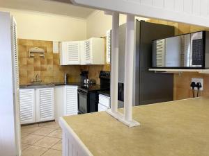 uma cozinha com armários brancos e electrodomésticos pretos em Sombedu guest suite em Margate