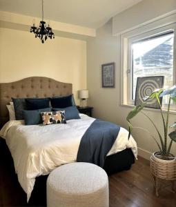 Un dormitorio con una cama grande y una ventana en Mosaic Suite at The Inn On The Drive, en Vancouver
