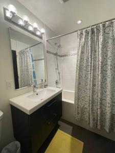 a bathroom with a sink and a shower curtain at Mosaic Suite at The Inn On The Drive in Vancouver