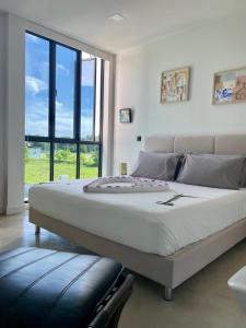 a large bed in a room with a large window at EQ SURF RETREAT in Muli