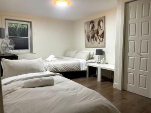 sypialnia z 2 łóżkami, stołem i drzwiami w obiekcie Patio Suite at The Inn On The Drive w mieście Vancouver