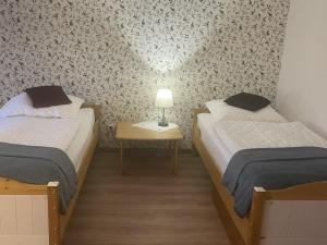 um quarto com 2 camas e uma mesa com um candeeiro em NEU! Ferienwohnung Ostseebeere em Groß Zastrow