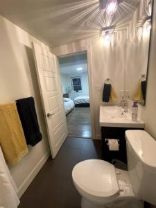 a bathroom with a white toilet and a sink at Patio Suite at The Inn On The Drive in Vancouver