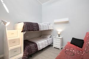 a small bedroom with two bunk beds and a red chair at Casa tia osa in Arico