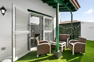 a patio with chairs and a table on the grass at Casa tia osa in Arico