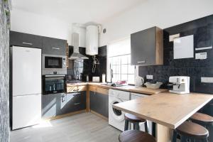 cocina con mesa de madera y nevera blanca en Casa tia osa en Arico