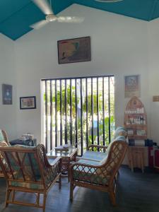 a room with chairs and a table and a window at EQ SURF RETREAT in Muli