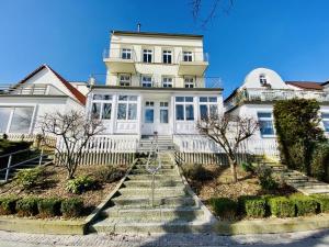 uma grande casa branca com escadas em frente em Stromschnelle, direkt am Alten Strom em Warnemünde