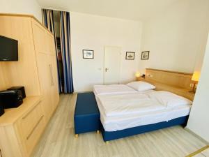 um pequeno quarto com uma cama e uma televisão em Stromschnelle, direkt am Alten Strom em Warnemünde