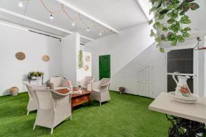una sala de estar con paredes blancas y césped verde en La Casa de Tina en Playa de San Juan