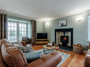 3 Bed in Crieff 78313 في Madderty: غرفة معيشة مع أثاث من الجلد ومدفأة