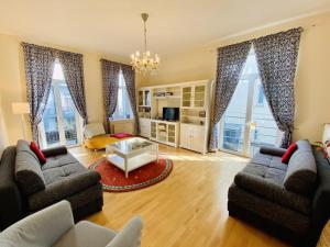 uma sala de estar com 2 sofás e janelas grandes em Riga em Warnemünde
