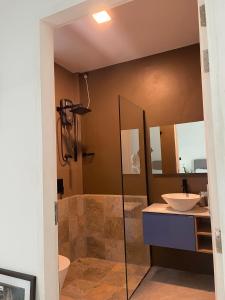 a bathroom with a shower and a sink at EQ SURF RETREAT in Muli