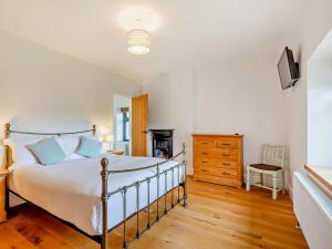 a bedroom with a bed and a wooden floor at 5 Bed in Ashbrittle 77900 
