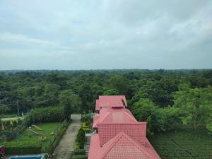 a pink building with a playground in a park at Maa Greenary View - A Holiday Resort in Alīpur Duār