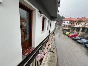 un balcón de un edificio con coches aparcados en una calle en AGAPI’S HOUSE, en Metsovo